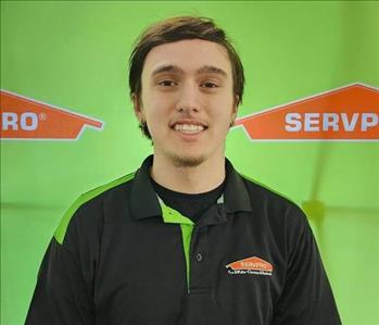 Male employee in front of green wall